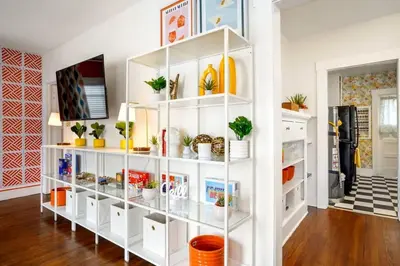 a white book shelf with plants on it in a room at Bright and Quirky Hillcrest Craftsman in San Diego