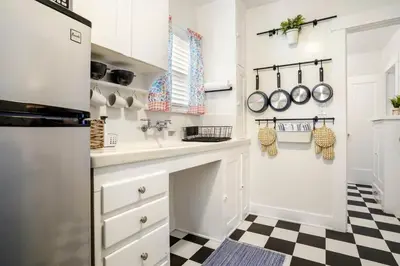 a kitchen with white cabinets and a black and white checkered floor at Adorable Quirky Hideaway BIG Private Enclosed Yard in San Diego