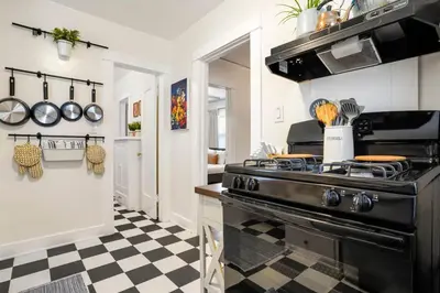 a kitchen with a black stove and a checkered floor at Adorable Quirky Hideaway BIG Private Enclosed Yard in San Diego