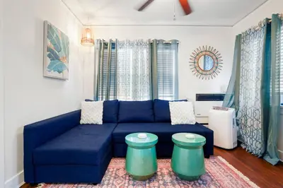 a living room with a blue couch and two stools at Adorable Quirky Hideaway BIG Private Enclosed Yard in San Diego