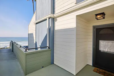 a house with a balcony with a door and the ocean at 152-4 Coastal Luxury with Panoramic Ocean View in Oceanside