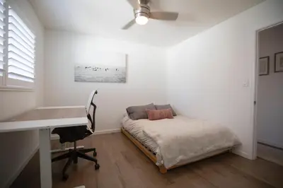 a white bedroom with a bed and a desk at The Atlas in San Diego
