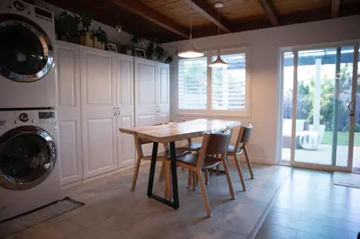 a kitchen with a table and chairs and a washer and dryer at The Atlas in San Diego