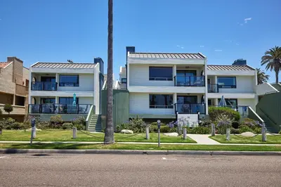 a white building with a palm tree in front of it at 152-6 S Pacific Fantastic Ocean View in Oceanside