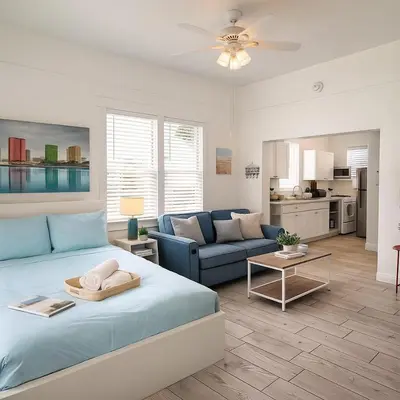 a bedroom with a blue bed and a living room at Urban Nest with private Patio in Golden Hill - walk everywhere! in San Diego