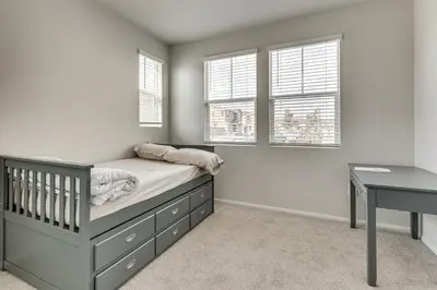 a bedroom with a crib and a desk and windows at Near Hospitals Home with Pool Access in Temecula in Temecula