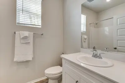 a white bathroom with a toilet and a sink at Near Hospitals Home with Pool Access in Temecula in Temecula