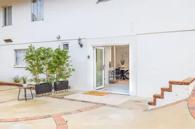 a white house with a patio with a table and chairs at Brand New Studio in Carlsbad in Carlsbad