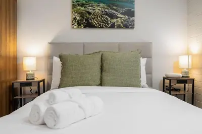 a bedroom with a white bed with two lamps at Brand New Studio in Carlsbad in Carlsbad