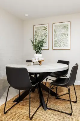 a dining room table with two chairs and a vase on it at Brand New Studio in Carlsbad in Carlsbad
