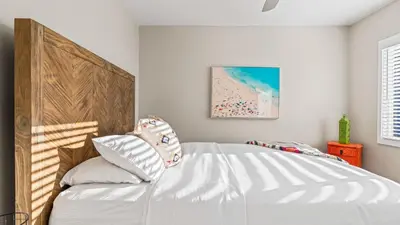 a bedroom with a large white bed with pillows at Steps to the Beach Hot Tub Fire Pit 257 Trailhead Trestles 2 by AvantStay in San Clemente