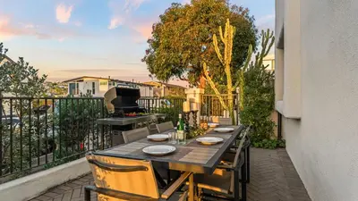 a table on a balcony with a grill at Steps to the Beach Modern 3BDR w Patio 257 Trailhead Trestles 1 by AvantStay in San Clemente