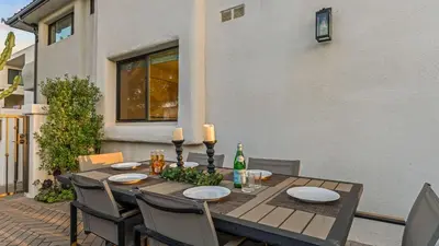 a wooden table with plates and candles on a patio at Steps to the Beach Modern 3BDR w Patio 257 Trailhead Trestles 1 by AvantStay in San Clemente