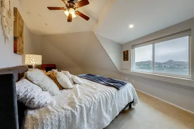 a bedroom with a bed with a ceiling fan and a window at Near Hiking Trails! Luxe Family Home in Lakeside in Lakeside