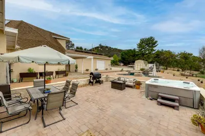 a patio with a hot tub and tables and chairs at Near Hiking Trails! Luxe Family Home in Lakeside in Lakeside