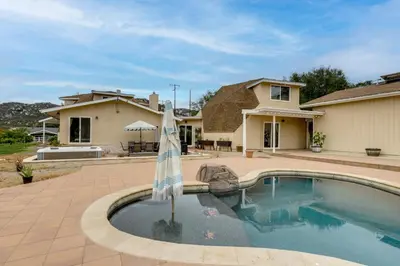 a swimming pool with an umbrella in front of a house at Near Hiking Trails! Luxe Family Home in Lakeside in Lakeside