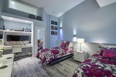 a bedroom with two beds and a desk and a tv at Stunning 4 BR 3 BA Convention Center Gaslamp Petco in San Diego