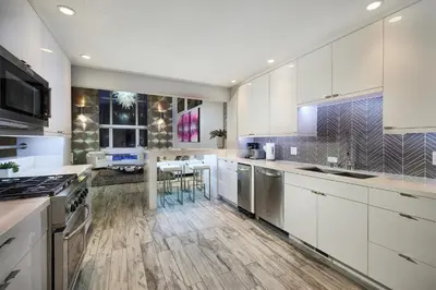 a kitchen with white cabinets and stainless steel appliances at Stunning 4 BR 3 BA Convention Center Gaslamp Petco in San Diego