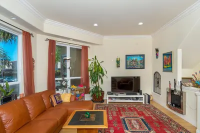 a living room with a brown leather couch and a tv at Oceanview Beach Home - 209W in Oceanside