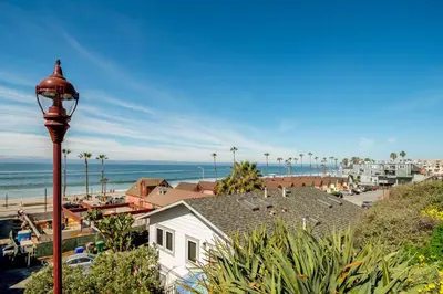 a street light next to a white house and a beach at Oceanview Beach Home - 209W in Oceanside