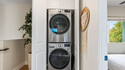 a washing machine and a dryer in a room at 2 Condos Steps to the Beach Hot Tub Trestles Trailhead Duo by AvantStay in San Clemente