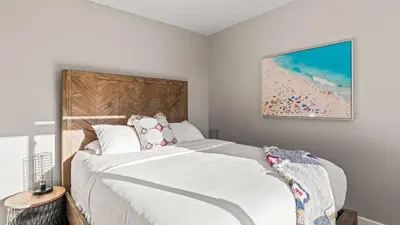 a bedroom with a large bed with white sheets at 2 Condos Steps to the Beach Hot Tub Trestles Trailhead Duo by AvantStay in San Clemente