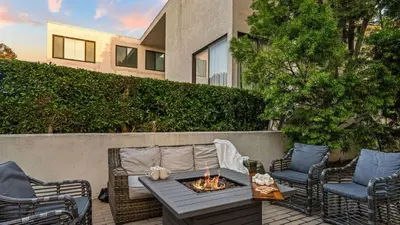 a patio with chairs and a table with a fire pit at 2 Condos Steps to the Beach Hot Tub Trestles Trailhead Duo by AvantStay in San Clemente
