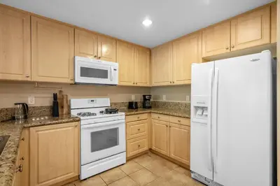 a kitchen with white appliances and wooden cabinets at Modern 2BR Cozy Apartment in Irvine in Lake Forest