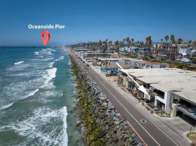 a kite flying over a beach next to the ocean at 700-104 Water Front Condo w AC in Oceanside