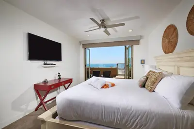 a bedroom with a bed with a desk and a television at 700-104 Water Front Condo w AC in Oceanside