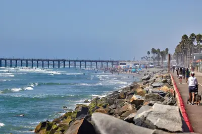 people walking on the beach near a pier at 700-104 Water Front Condo w AC in Oceanside
