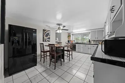 a kitchen with a black refrigerator and a table with chairs at Entire Private Home with 4 Bedrooms 2 Bathrooms, 6 Beds, Hot Tub, King Bed, 6 Parking, Big Yard, Available Now in Spring Valley