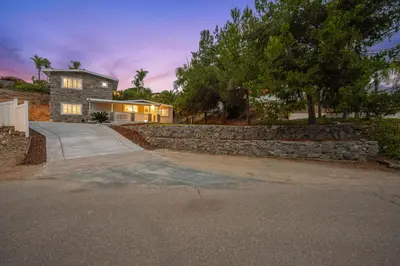 a house with a stone retaining wall and a driveway at Entire Private Home with 4 Bedrooms 2 Bathrooms, 6 Beds, Hot Tub, King Bed, 6 Parking, Big Yard, Available Now in Spring Valley