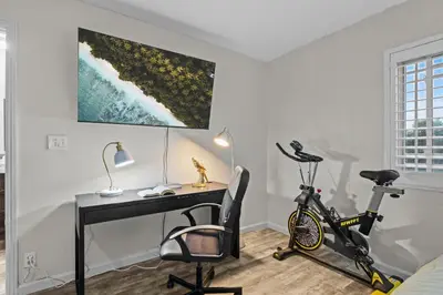 a desk and a bike in a room with a desk at Entire Private Home with 4 Bedrooms 2 Bathrooms, 6 Beds, Hot Tub, King Bed, 6 Parking, Big Yard, Available Now in Spring Valley