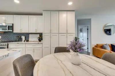 a kitchen with a table with a vase of flowers on it at 4 Mi to Dtwn Oceanside and Beach Home with Yard! in Oceanside