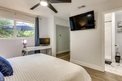 a bedroom with a bed and a desk and a television at 4 Mi to Dtwn Oceanside and Beach Home with Yard! in Oceanside