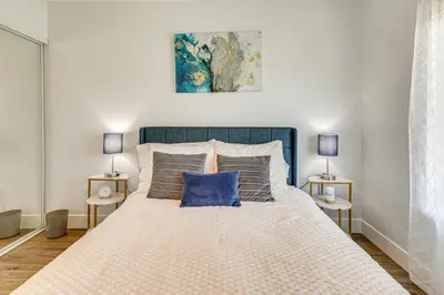 a bedroom with a large bed with a blue headboard at 4 Mi to Dtwn Oceanside and Beach Home with Yard! in Oceanside