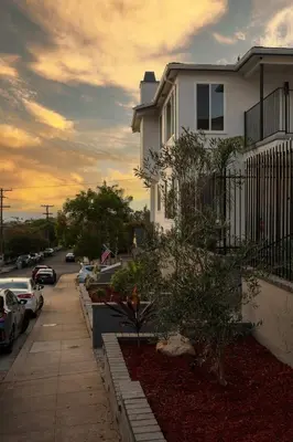 a white house with cars parked in a parking lot at Bridgeview Retreat Near Balboa Park in San Diego