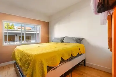 a bedroom with a yellow bed with a window at Oasis Hillcrest in San Diego
