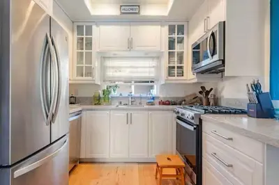 a kitchen with white cabinets and a stainless steel refrigerator at Oasis Hillcrest in San Diego