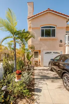a car parked in front of a house with a palm tree at Oasis Hillcrest in San Diego