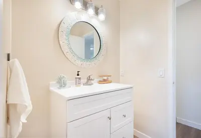 a white bathroom with a sink and a mirror at Sunrise & Sunset by the Sea 812-1 in Oceanside