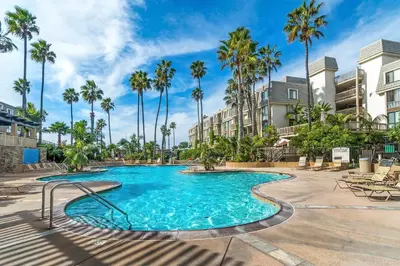 a swimming pool at a resort with palm trees at North Coast Village B212 in Oceanside