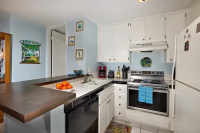 a kitchen with white cabinets and a sink at North Coast Village B212 in Oceanside