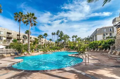 a swimming pool at a resort with palm trees at North Coast Village B212 in Oceanside