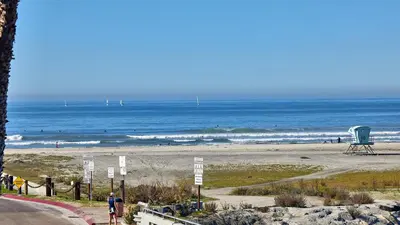 a beach with a blue chair and the ocean at North Coast Village Cottage G20 in Oceanside