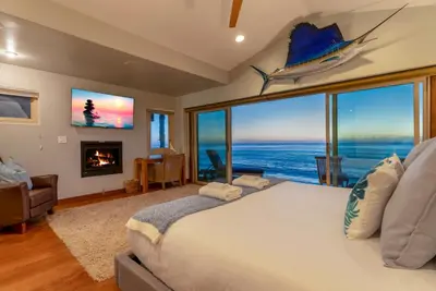 a bedroom with a large bed with a view of the ocean at Oceanfront at Windansea Luxe 3-Story Home with Views, AC, Garage in San Diego