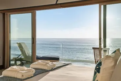 a room with a view of the ocean with towels on a bed at Oceanfront at Windansea Luxe 3-Story Home with Views, AC, Garage in San Diego