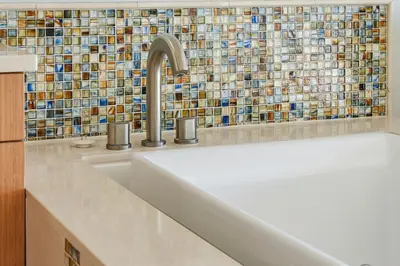 a kitchen with a sink and a mosaic wall at Oceanfront at Windansea Luxe 3-Story Home with Views, AC, Garage in San Diego