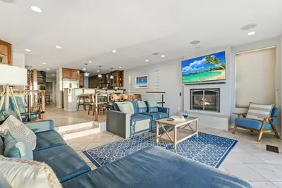 a living room with blue furniture and a fireplace at Oceanfront at Windansea Luxe 3-Story Home with Views, AC, Garage in San Diego